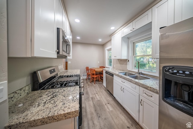 252 E 1000 N, Logan, UT 84321 - kitchen with stainless steel appliances, light wood-style floors, white cabinetry, recessed lighting, and light stone counters