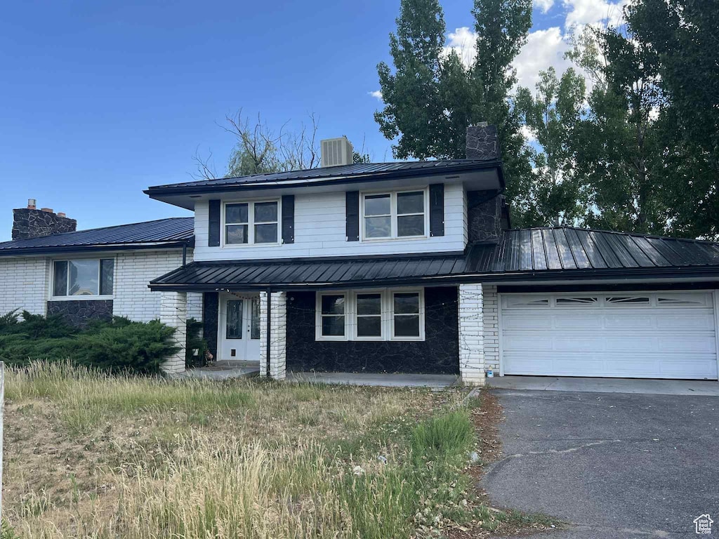 736 E 1500 N, Vernal, UT 84078 - view of front of property with a chimney, brick siding, a garage, and a metal roof