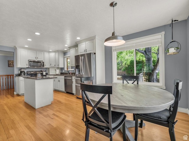 1834 N 200 E, Centerville, UT 84014 - kitchen with appliances with stainless steel finishes, dark countertops, light wood-style floors, white cabinetry, and recessed lighting