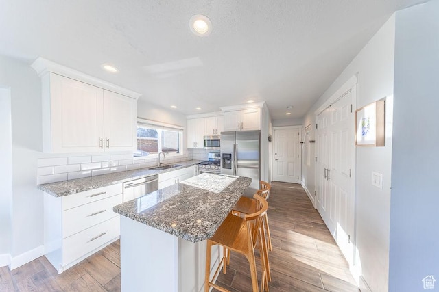 788 E 8230 S, Sandy, UT 84094 - kitchen with appliances with stainless steel finishes, a breakfast bar area, light wood-style floors, tasteful backsplash, and recessed lighting