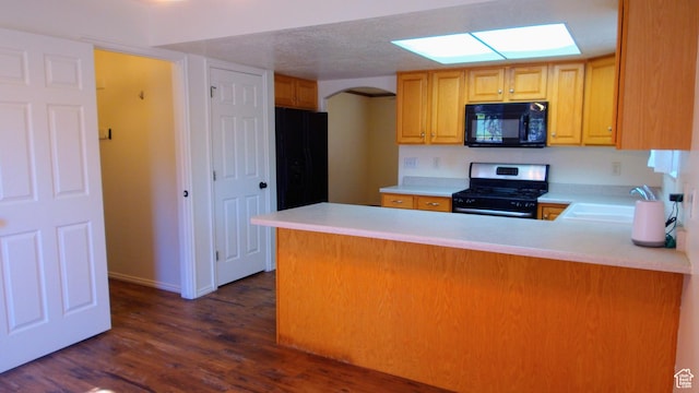 85 Hampton Pl N, Logan, UT 84341 - kitchen with stainless steel range with gas stovetop, black microwave, arched walkways, dark wood-style floors, and light countertops