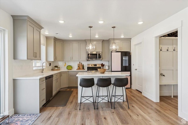 3380 W 3275 N, Plain City, UT 84404 - kitchen with appliances with stainless steel finishes, gray cabinetry, light wood-type flooring, a kitchen bar, and recessed lighting