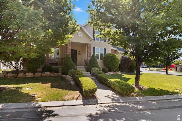 889 S Sego Lily Way, Mapleton, UT 84664 - view of property hidden behind natural elements with a front yard, stucco siding, brick siding, and covered porch