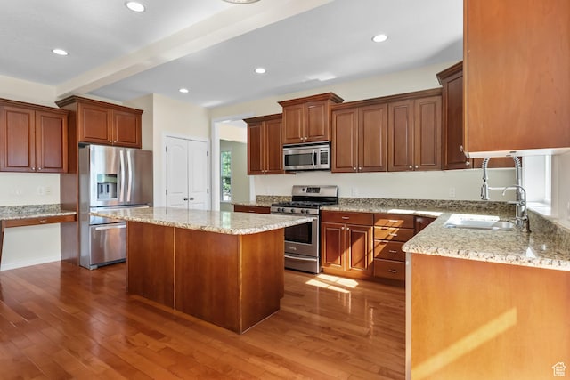 889 S Sego Lily Way, Mapleton, UT 84664 - kitchen with stainless steel appliances, beamed ceiling, wood finished floors, a kitchen island, and light stone counters