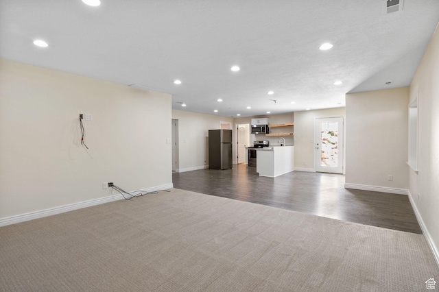 889 S Sego Lily Way, Mapleton, UT 84664 - unfurnished living room featuring dark colored carpet, recessed lighting, and dark wood finished floors
