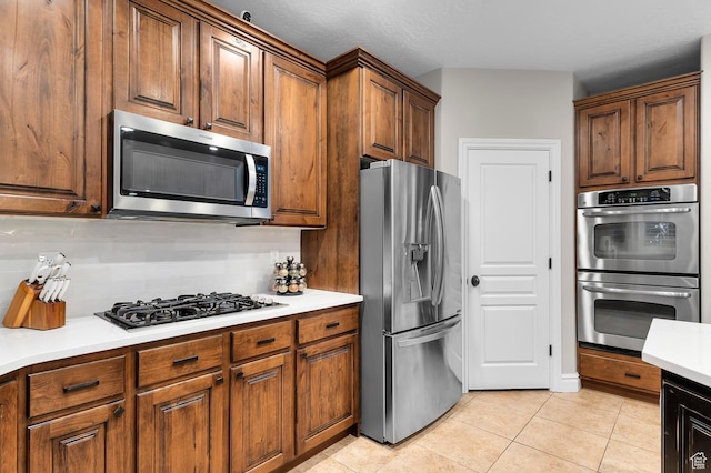 292 E Clubview Ln, Lehi, UT 84043 - kitchen with appliances with stainless steel finishes, light tile patterned floors, light countertops, and brown cabinetry