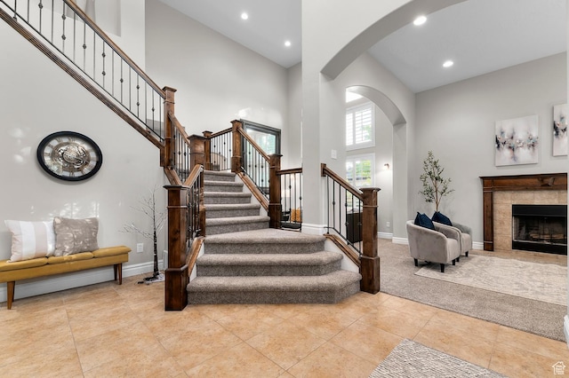 292 E Clubview Ln, Lehi, UT 84043 - stairs with arched walkways, a towering ceiling, recessed lighting, a tiled fireplace, and tile patterned floors