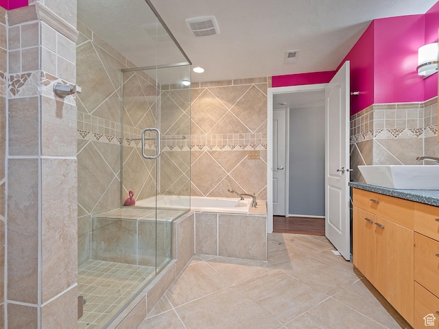 4525 S Taylor Ave E, Ogden, UT 84403 - full bath with tile walls, vanity, a shower stall, a garden tub, and tile patterned floors