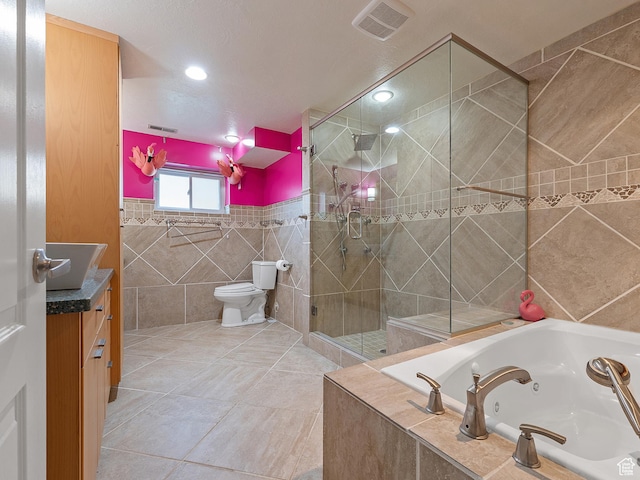 4525 S Taylor Ave E, Ogden, UT 84403 - bathroom with tile walls, a jetted tub, vanity, a stall shower, and tile patterned floors