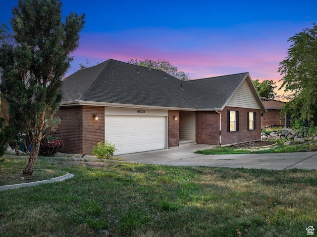 4525 S Taylor Ave E, Ogden, UT 84403 - view of front facade featuring concrete driveway, brick siding, an attached garage, a lawn, and roof with shingles