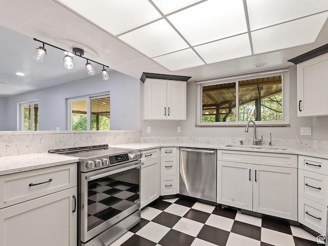 4525 S Taylor Ave E, Ogden, UT 84403 - kitchen with stainless steel appliances, dark flooring, white cabinetry, and light stone countertops