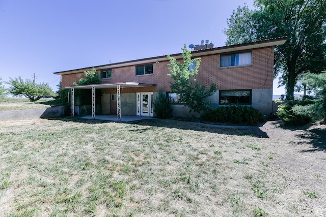 869 N 1600 E, Preston, ID 83263 - view of front facade featuring brick siding, a patio, and a front lawn