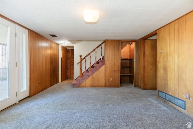 869 N 1600 E, Preston, ID 83263 - unfurnished living room featuring carpet floors, stairs, and wooden walls