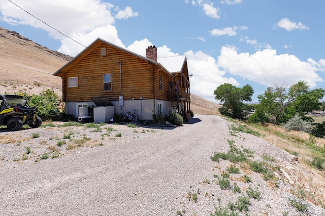 440 N Quarry Rd, Salina, UT 84654 - view of side of home with log exterior, a chimney, a metal roof, and gravel driveway