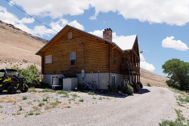 440 N Quarry Rd, Salina, UT 84654 - view of side of home with log exterior, a chimney, a metal roof, and a mountain view