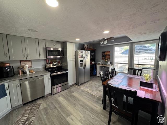 5981 S Sultan Cir, Murray, UT 84107 - kitchen featuring appliances with stainless steel finishes, a textured ceiling, light wood finished floors, a ceiling fan, and light countertops