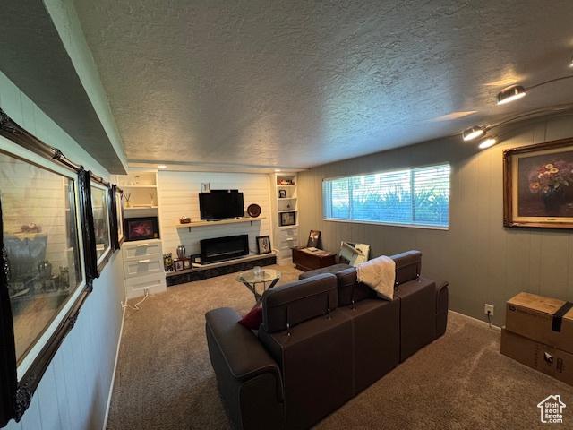 4650 S Chapel Dr E, Salt Lake City, UT 84117 - carpeted living room with a textured ceiling and a fireplace with raised hearth