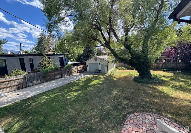4650 S Chapel Dr E, Salt Lake City, UT 84117 - view of yard featuring driveway, an outdoor structure, and a detached garage