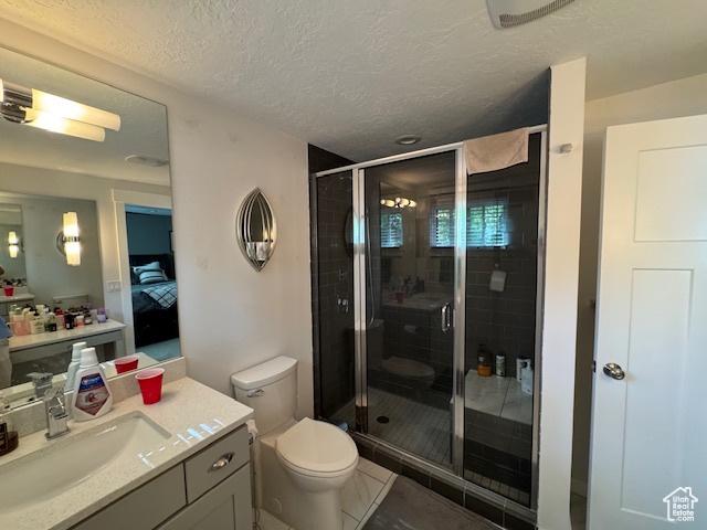 4650 S Chapel Dr E, Salt Lake City, UT 84117 - ensuite bathroom featuring vanity, a shower stall, and a textured ceiling