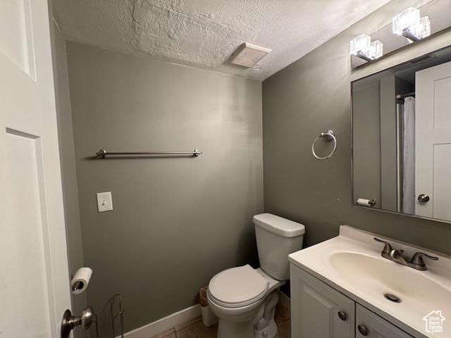 4650 S Chapel Dr E, Salt Lake City, UT 84117 - full bathroom featuring a textured ceiling, vanity, and tile patterned flooring