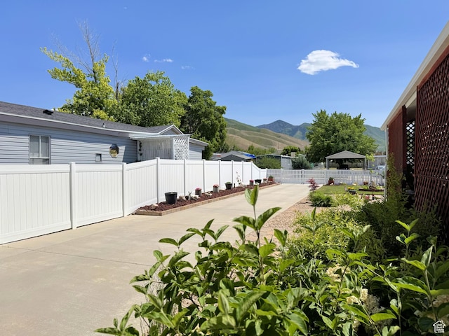 804 Fleetwood Dr, Tooele, UT 84074 - fenced backyard with a patio, a mountain view, and concrete driveway