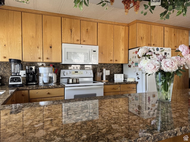 804 Fleetwood Dr, Tooele, UT 84074 - kitchen featuring white appliances, decorative backsplash, brown cabinets, and dark stone countertops