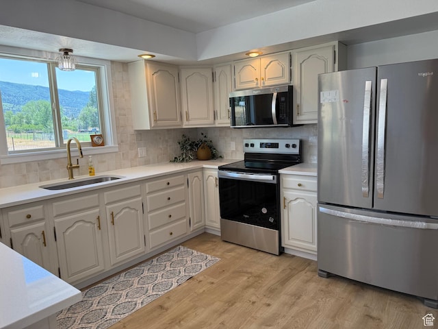 262 N 400 E, Fairview, UT 84629 - kitchen featuring appliances with stainless steel finishes, decorative backsplash, light wood-type flooring, and light countertops