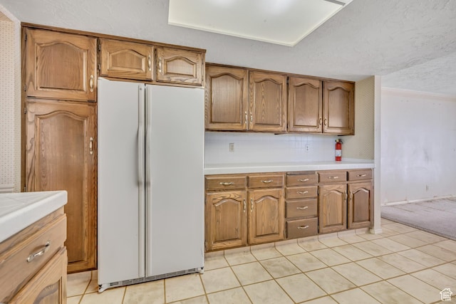 1936 S 800 E, Bountiful, UT 84010 - kitchen featuring freestanding refrigerator, light countertops, brown cabinetry, light tile patterned floors, and a textured ceiling