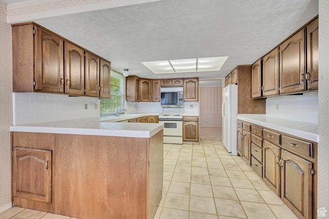 1936 S 800 E, Bountiful, UT 84010 - kitchen with white appliances, wallpapered walls, a peninsula, a textured ceiling, and light countertops