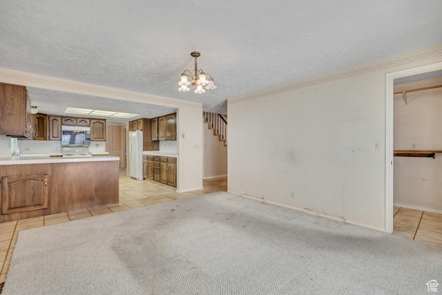 1936 S 800 E, Bountiful, UT 84010 - kitchen with stainless steel microwave, light tile patterned flooring, a chandelier, freestanding refrigerator, and light countertops