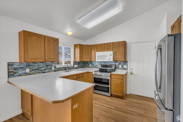 971 N 600 E, Springville, UT 84663 - kitchen featuring appliances with stainless steel finishes, a peninsula, lofted ceiling, light countertops, and backsplash