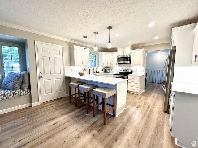 2442 N 2275 E, Layton, UT 84040 - kitchen featuring stainless steel appliances, light wood finished floors, a breakfast bar area, a peninsula, and ornamental molding