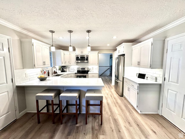 2442 N 2275 E, Layton, UT 84040 - kitchen with stainless steel appliances, a peninsula, crown molding, a textured ceiling, and light wood-type flooring