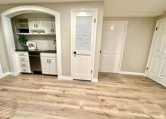 2442 N 2275 E, Layton, UT 84040 - bar with light wood finished floors, stainless steel dishwasher, backsplash, and arched walkways