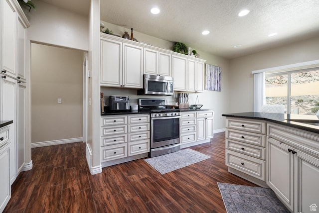 3486 W 1750 S, Vernal, UT 84078 - kitchen featuring appliances with stainless steel finishes, dark countertops, recessed lighting, white cabinetry, and dark wood-style flooring