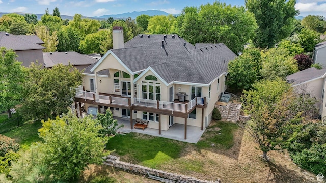 238 N Vista Ct, Saratoga Springs, UT 84045 - rear view of house featuring a patio, stucco siding, a deck, a chimney, and a lawn
