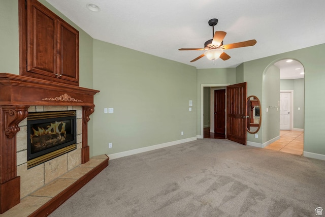238 N Vista Ct, Saratoga Springs, UT 84045 - unfurnished living room featuring a tiled fireplace, light colored carpet, a ceiling fan, arched walkways, and recessed lighting