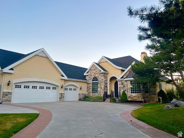 238 N Vista Ct, Saratoga Springs, UT 84045 - view of front of house featuring stucco siding, stone siding, driveway, and an attached garage