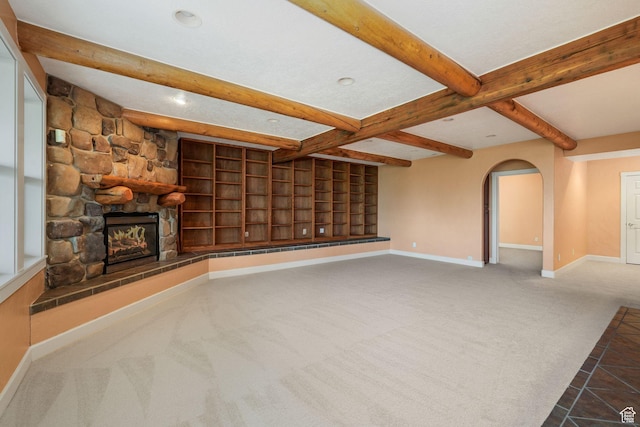 238 N Vista Ct, Saratoga Springs, UT 84045 - unfurnished living room featuring beamed ceiling, carpet floors, a fireplace, arched walkways, and tile patterned flooring