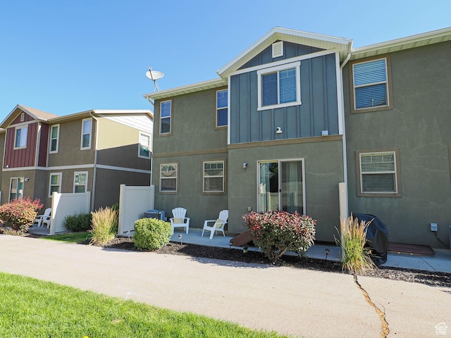 5229 W Armada Way, Herriman, UT 84096 - rear view of house with board and batten siding, a patio area, and stucco siding