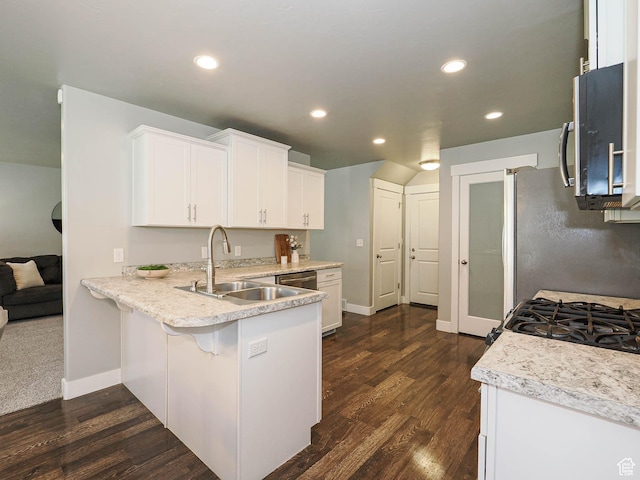 5229 W Armada Way, Herriman, UT 84096 - kitchen with appliances with stainless steel finishes, white cabinets, dark wood-style floors, a peninsula, and recessed lighting