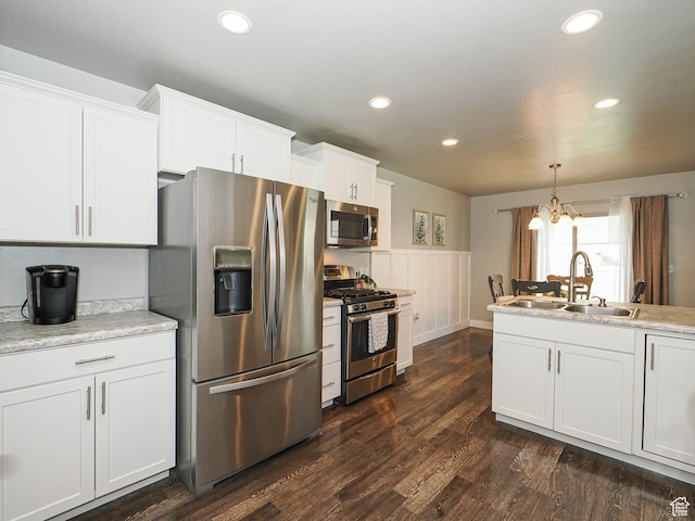 5229 W Armada Way, Herriman, UT 84096 - kitchen featuring stainless steel appliances, a chandelier, wainscoting, dark wood-style flooring, and white cabinetry
