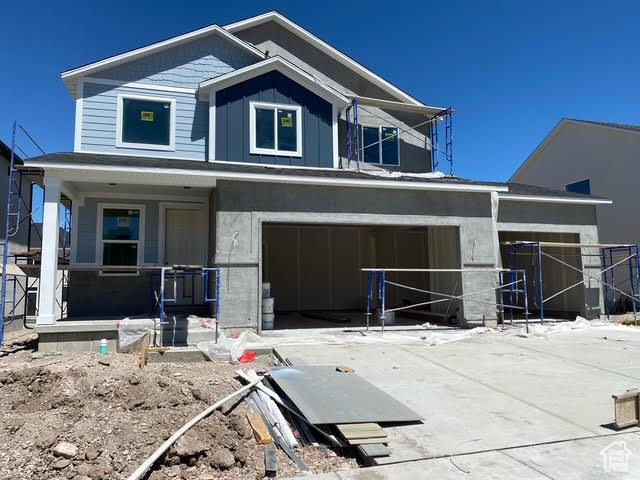 462 W Sapphire Dr Unit 7016, Tooele, UT 84074 - view of front of home featuring a porch, a garage, concrete driveway, and board and batten siding