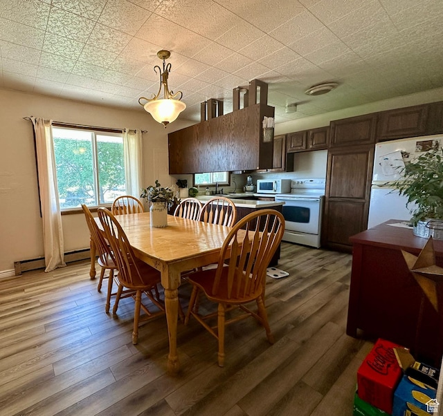 8744 E 6500 S, Jensen, UT 84035 - dining space with light wood-type flooring and a baseboard heating unit