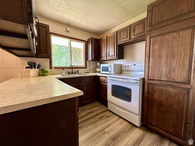 8744 E 6500 S, Jensen, UT 84035 - kitchen featuring white appliances, light wood finished floors, light countertops, and dark brown cabinets