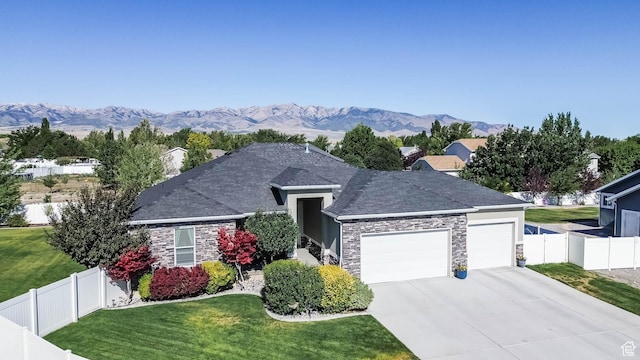 406 Zachary Way, Grantsville, UT 84029 - single story home with a garage, driveway, stone siding, a mountain view, and roof with shingles