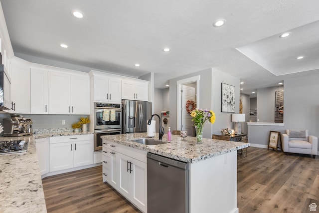 406 Zachary Way, Grantsville, UT 84029 - kitchen with appliances with stainless steel finishes, dark wood-type flooring, light stone counters, a center island with sink, and white cabinets