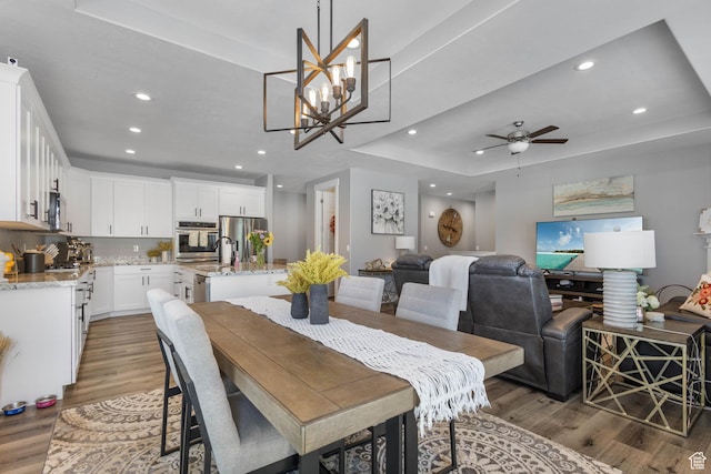 406 Zachary Way, Grantsville, UT 84029 - dining area with a tray ceiling, wood finished floors, recessed lighting, a ceiling fan, and a chandelier