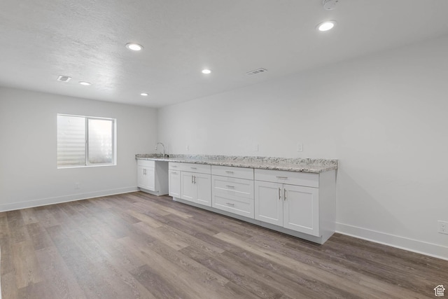 406 Zachary Way, Grantsville, UT 84029 - kitchen with wood finished floors, white cabinetry, light stone counters, recessed lighting, and stainless steel dishwasher