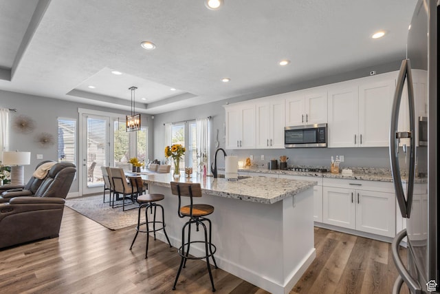 406 Zachary Way, Grantsville, UT 84029 - kitchen with stainless steel appliances, open floor plan, a raised ceiling, wood finished floors, and white cabinetry